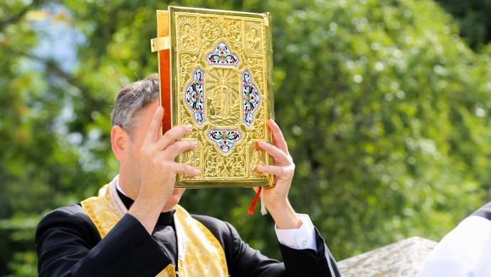 Priest raising the Gospel book at ITI liturgy